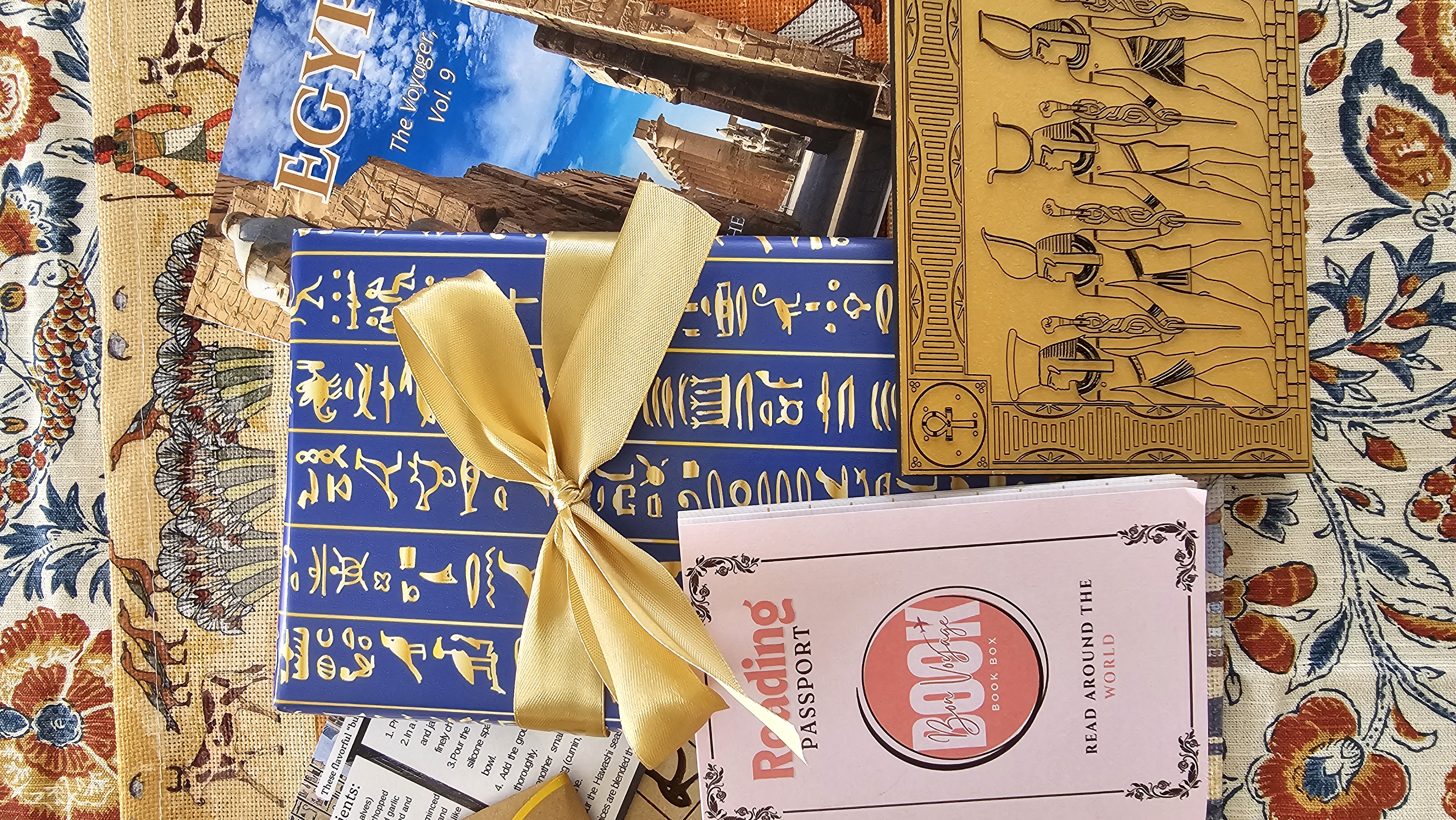 Wrapped Egyptian novel, travel guide, recipes, reading passport, and golden pharaoh souvenir