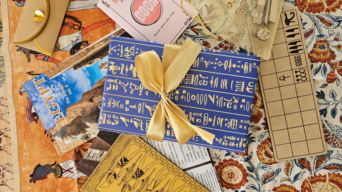 A giftwrapped book in Egyptian paper with a travel guide, recipes, and souvenirs 