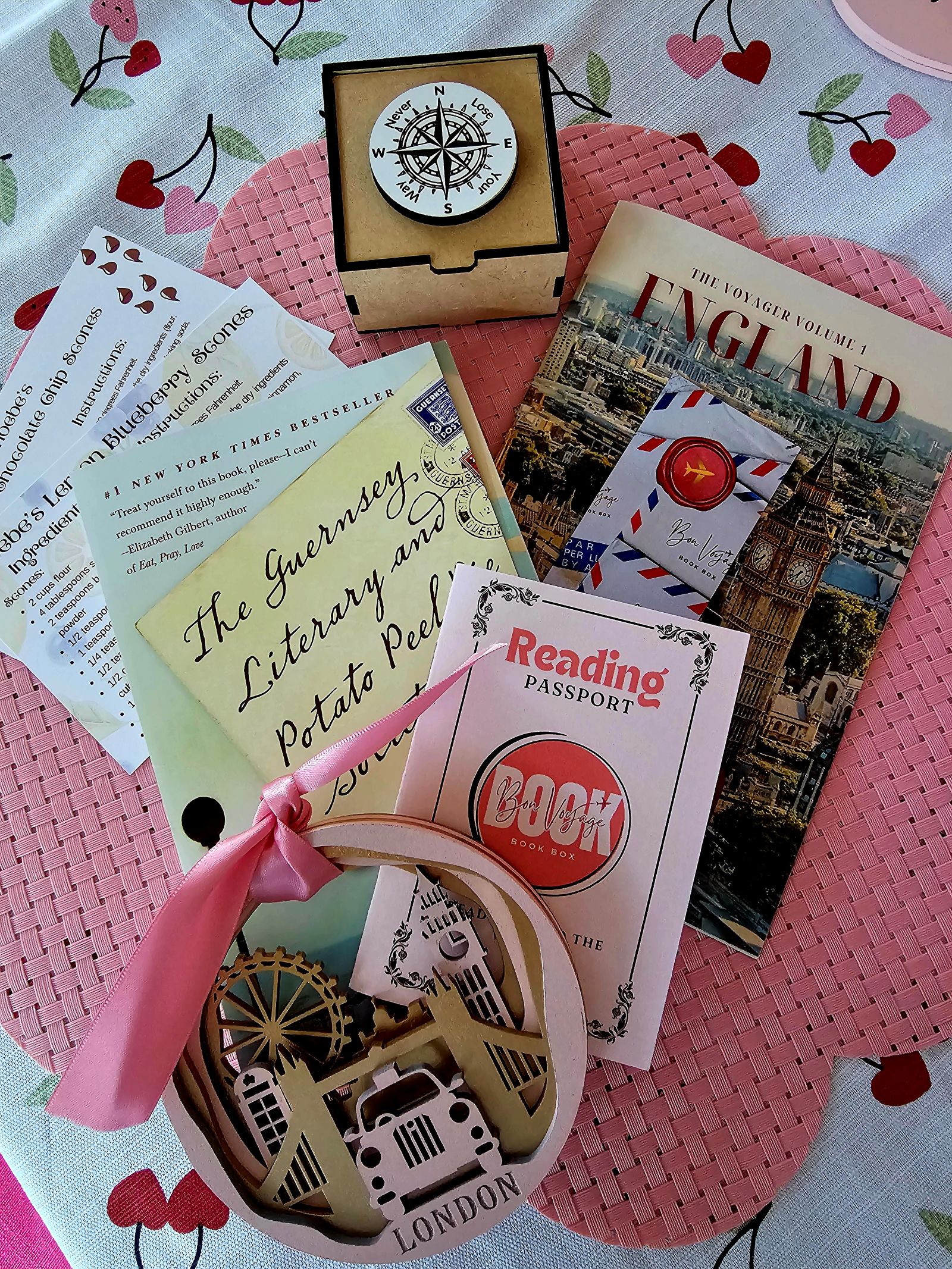 England book reveal, reading passport, travel guide, and a pink and gold London ornament