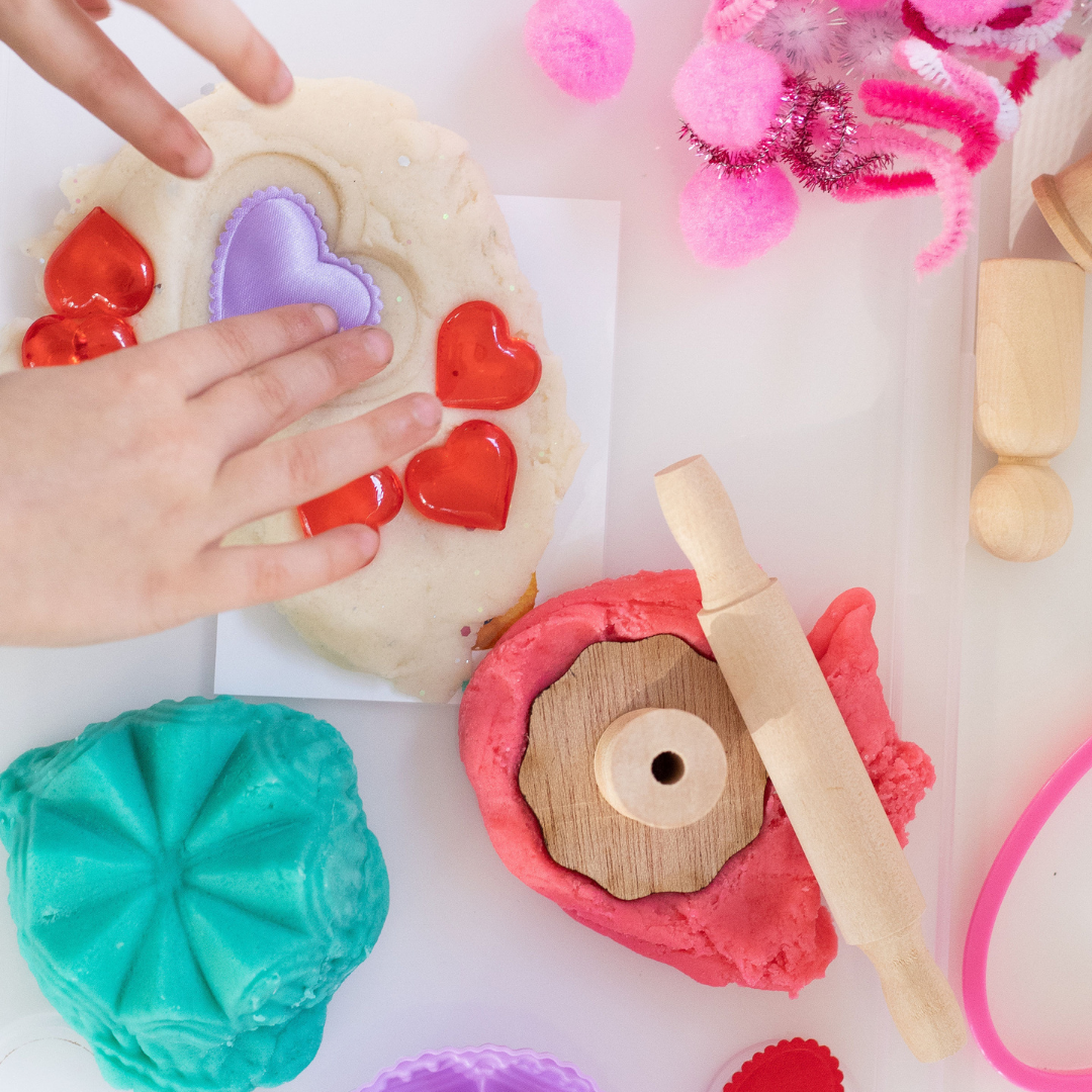 Child using their hands to create with Valentine's Day Sensory Kit