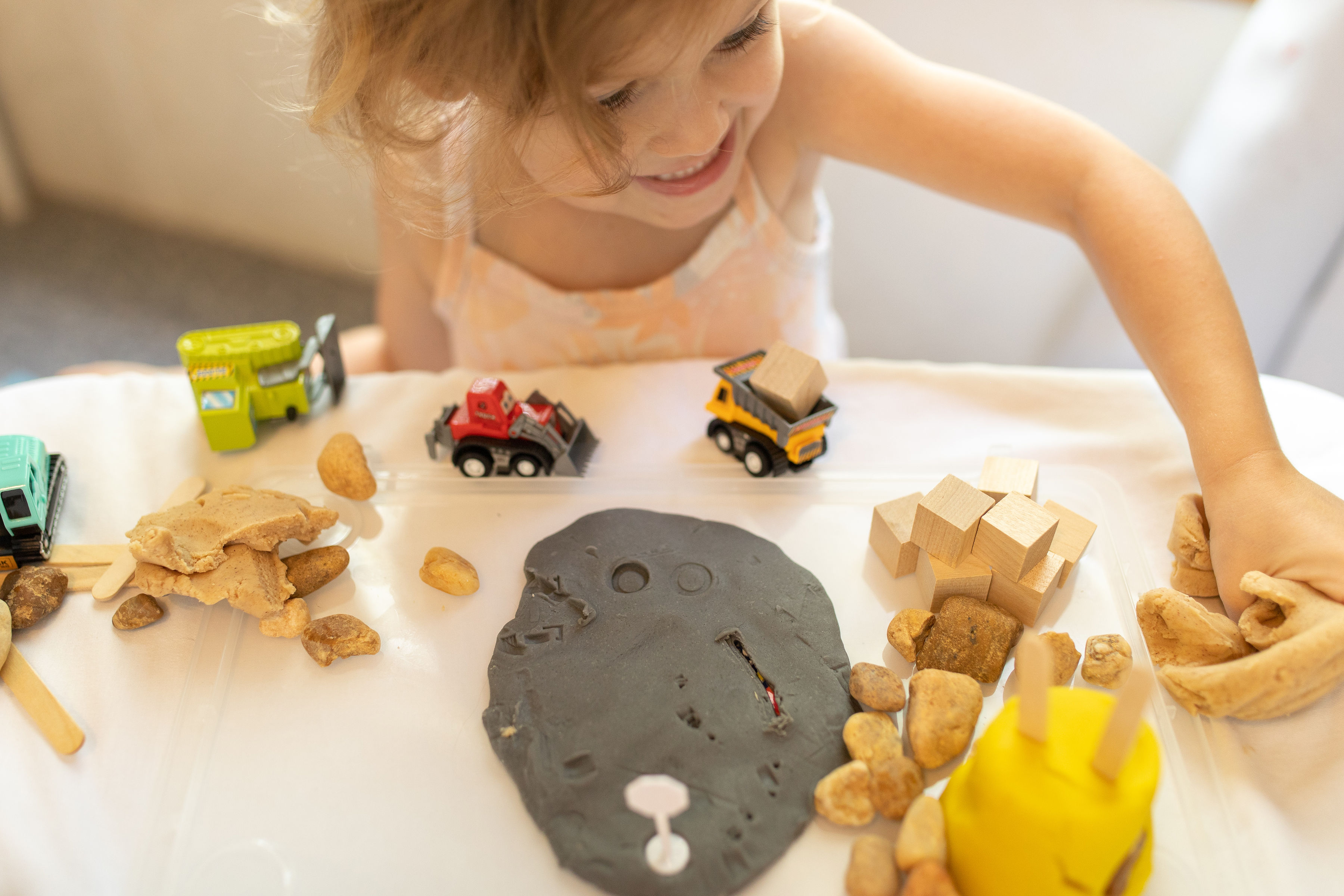 Broccoli Boxes Construction Sensory Kit dough being smashed, an example of fine motor practice