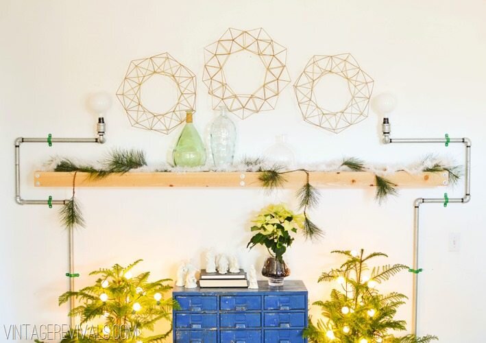 Three vintage geometric wreaths hang above a wooden mantlepiece.