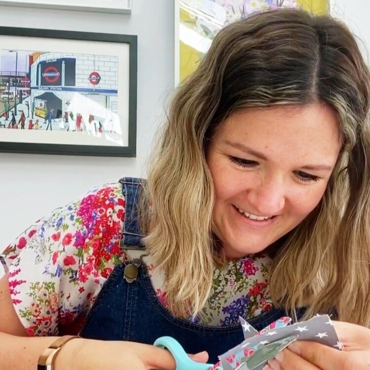 Photo shows Kirsty, a white woman in her thirties, enthusiastically cutting with scissors