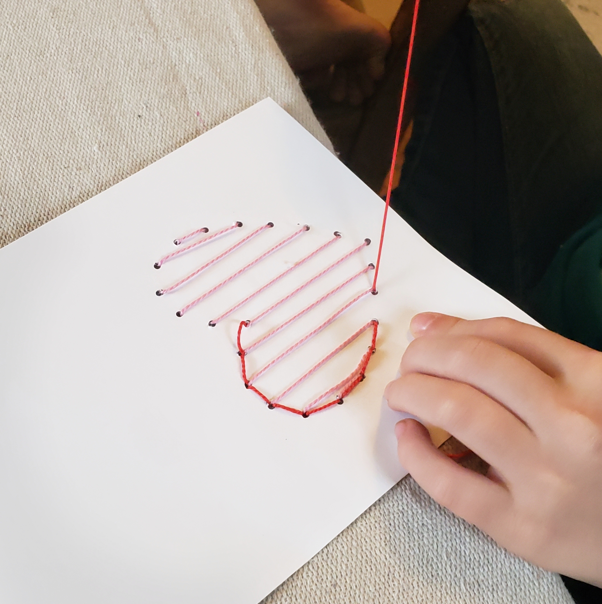 embroidering a heart on a card