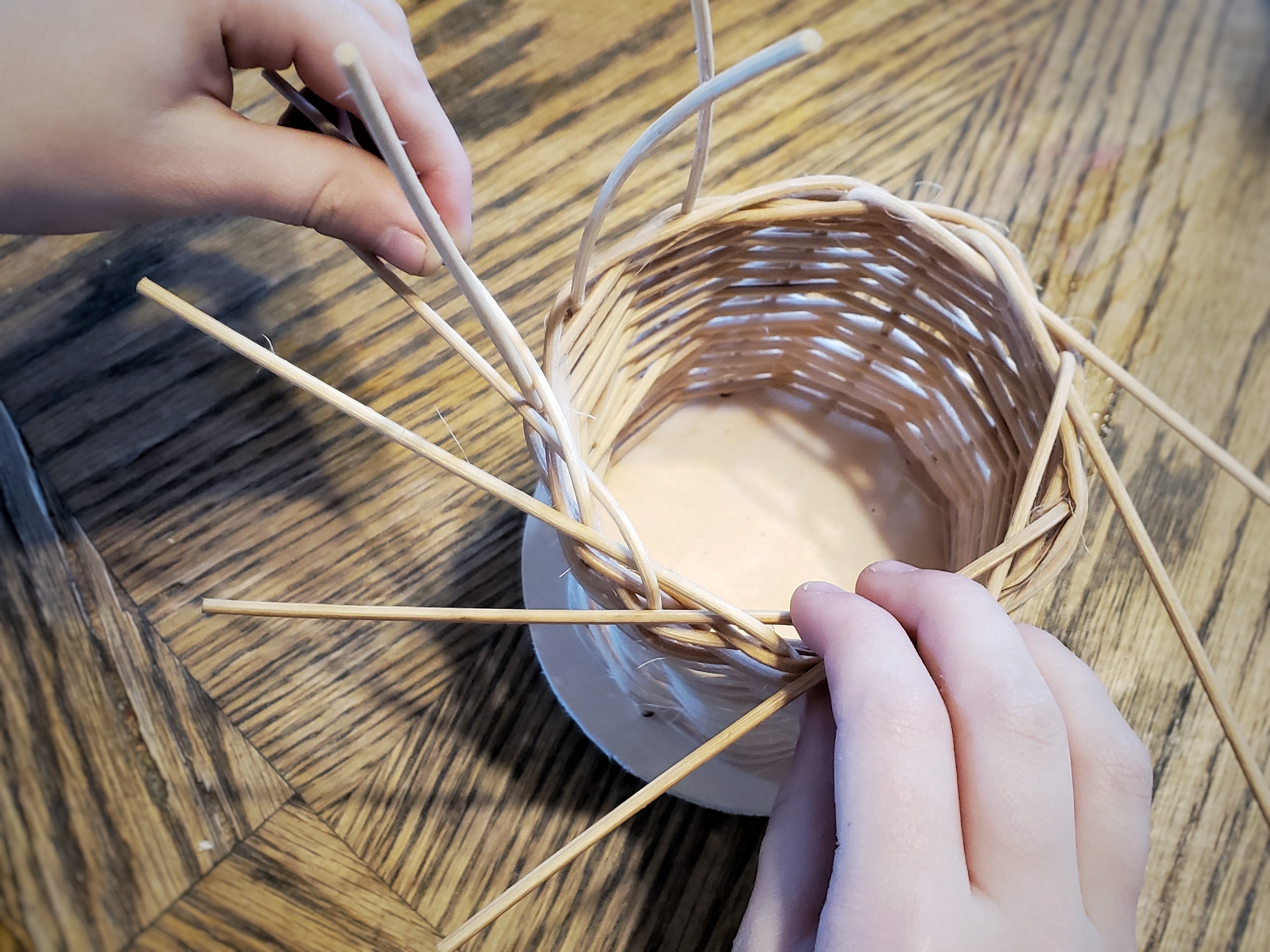 a simple reed basket in the final steps of weaving