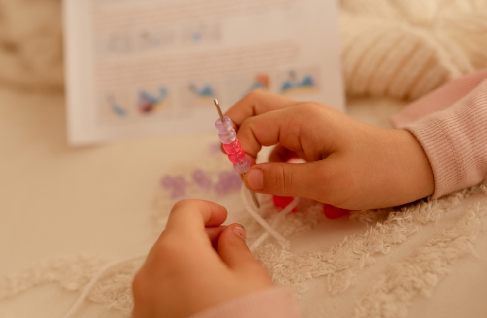 child stringing beads