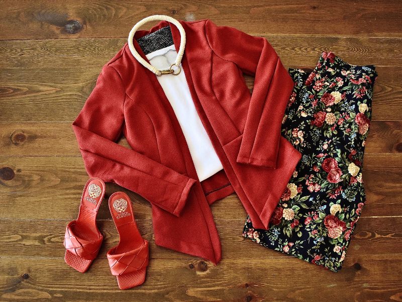 Flat lay of red shoes, red blazer, and matching floral pants