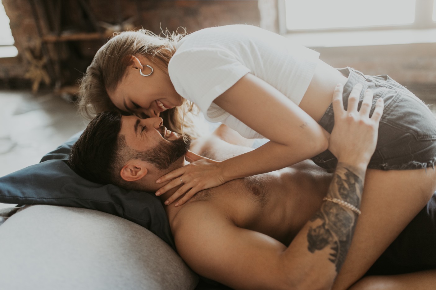woman strattling man with forheads touching and laughing
