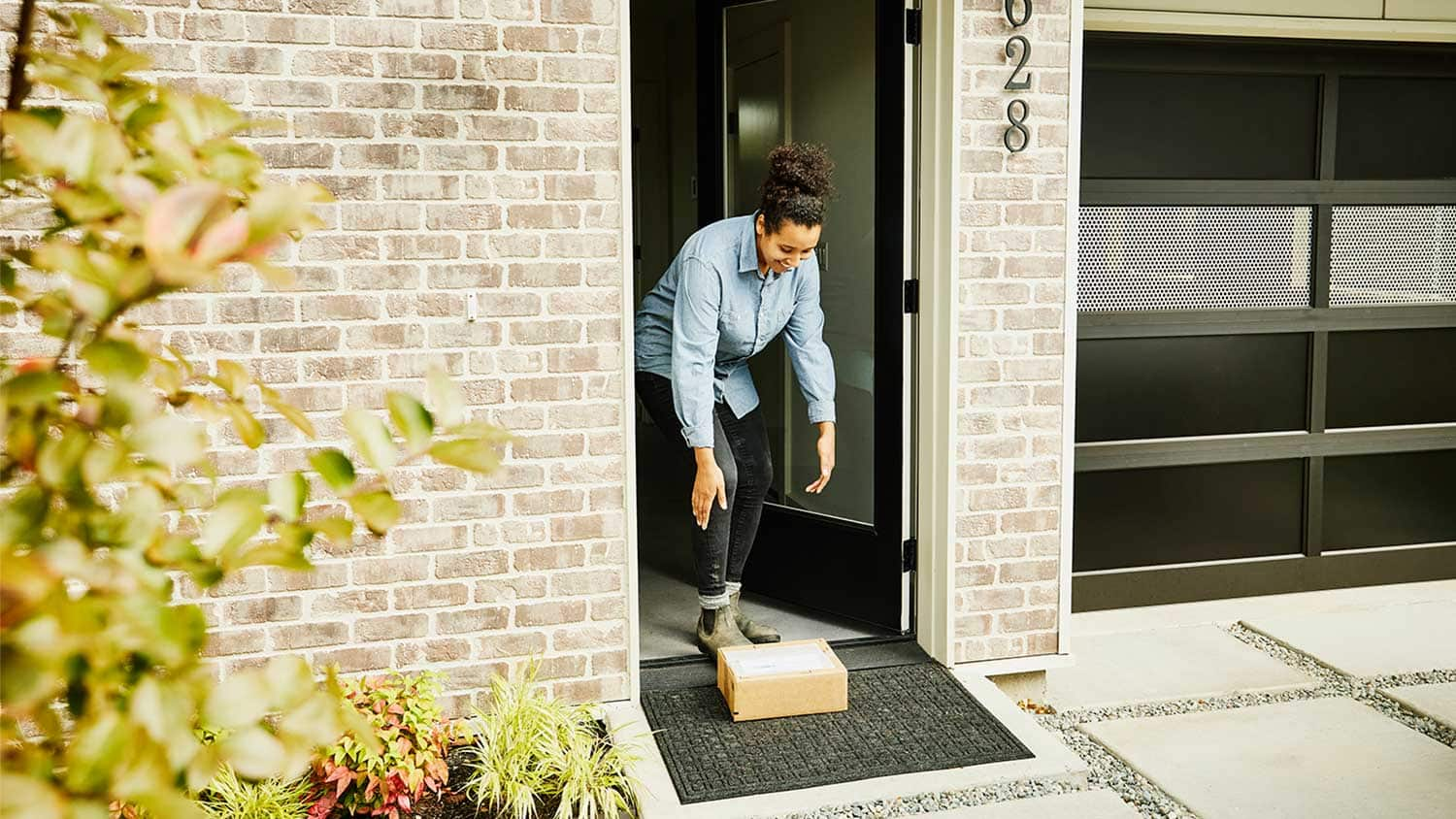 r243-woman-picking-up-package-front-door-16790164347749.jpeg