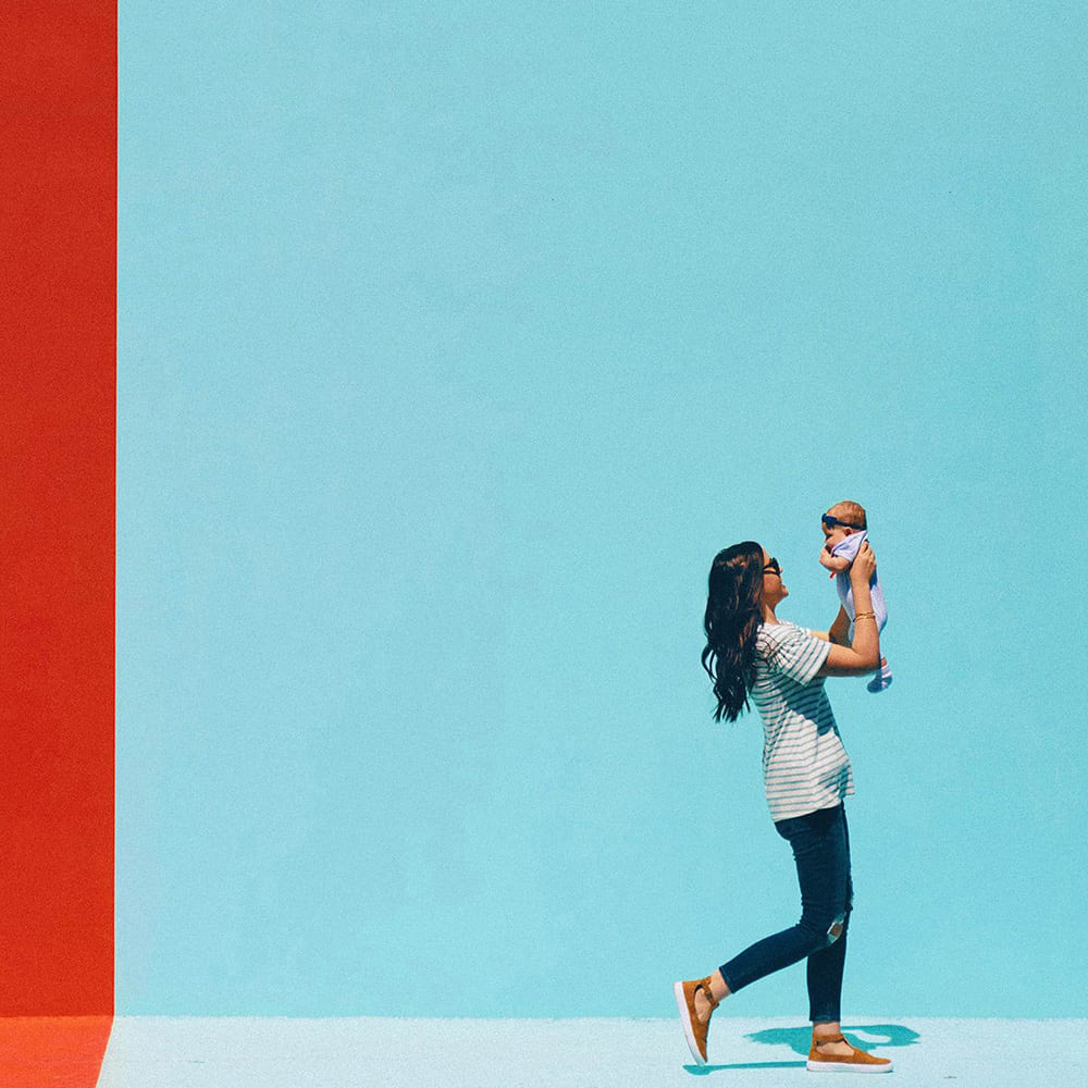 a mom carrying her baby wearing USA made children's clothes