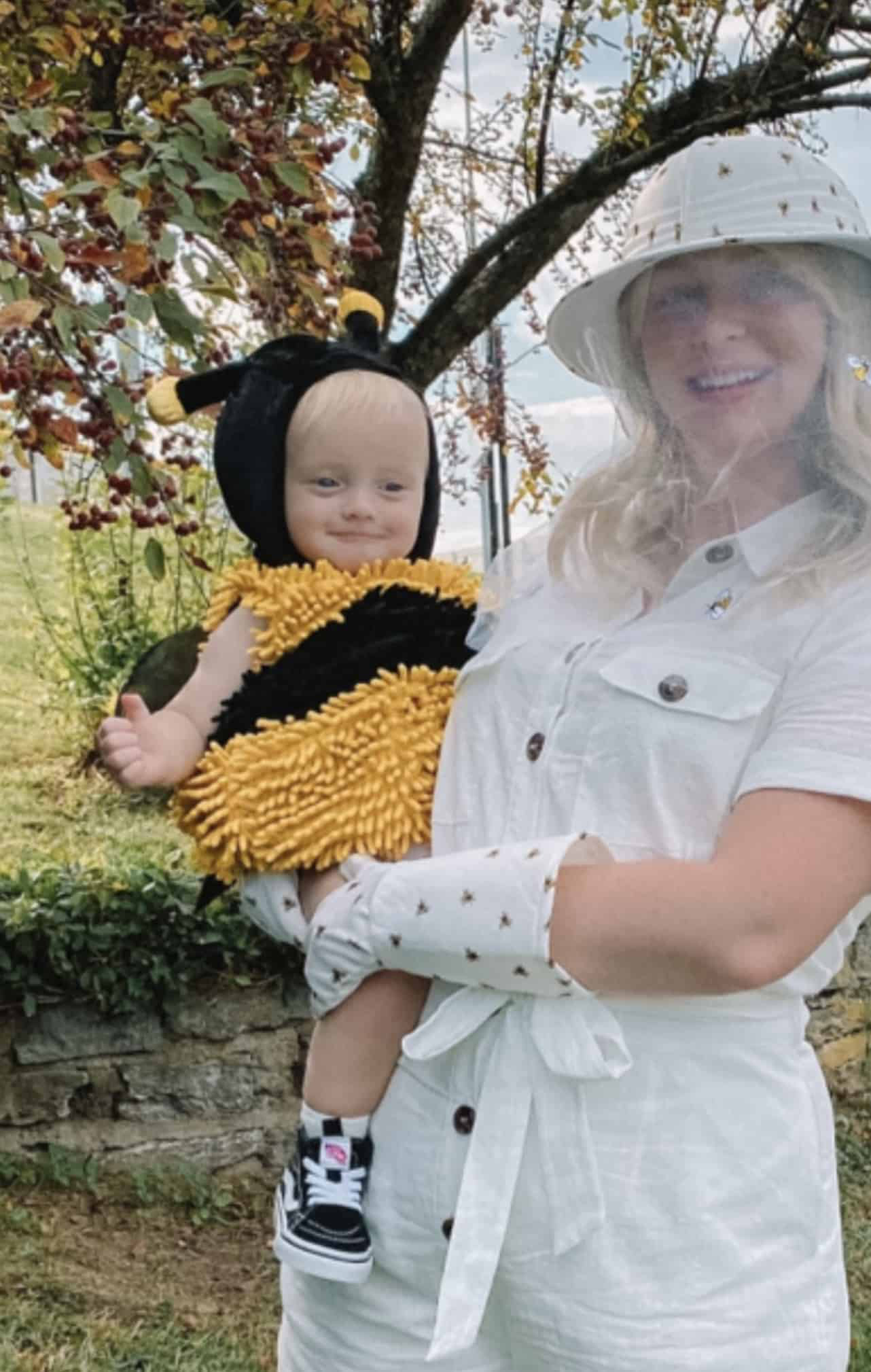 mom holding her baby boy in bee keeper and baby bee costumes
