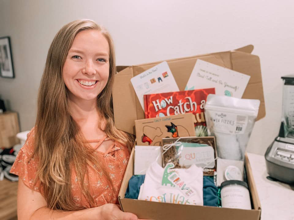 woman holding Howdy Baby subscription box for new moms babies, toddlers, and big kids