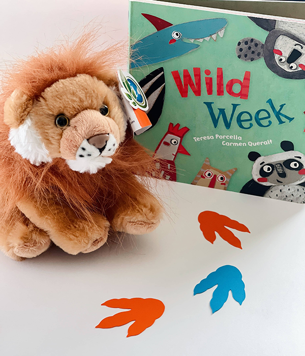 stuffed animal lion plushie sitting next to a wild week animal board book
