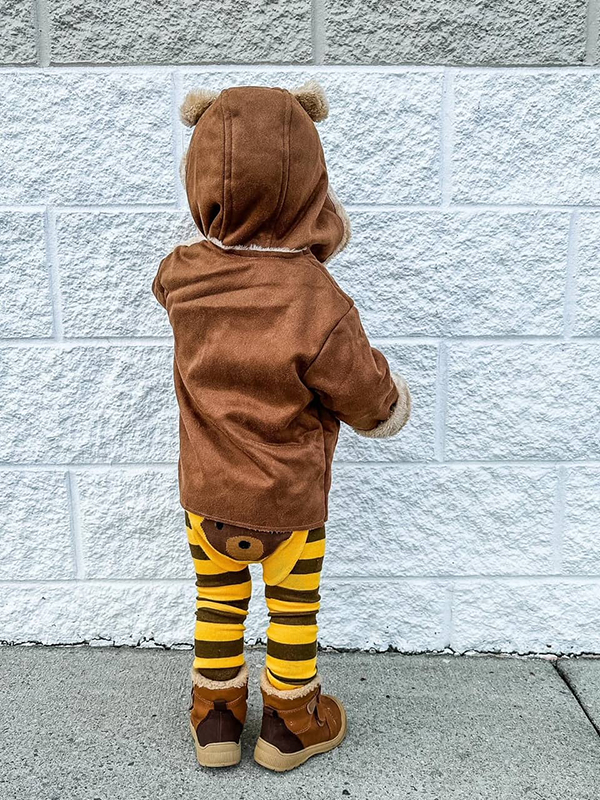 toddler wearing yellow and brown striped baby bear leggings and matching brown hooded coat
