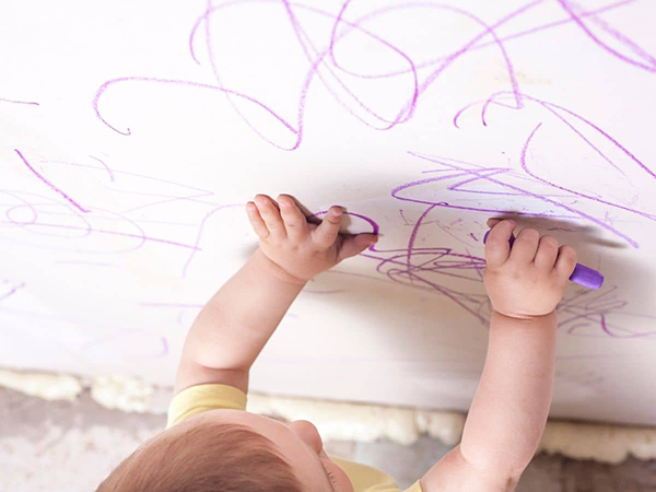 baby drawing on the walls with crayon