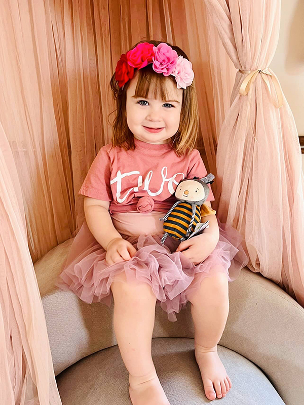 toddler girl holding buzzbee stuffed bee plushie