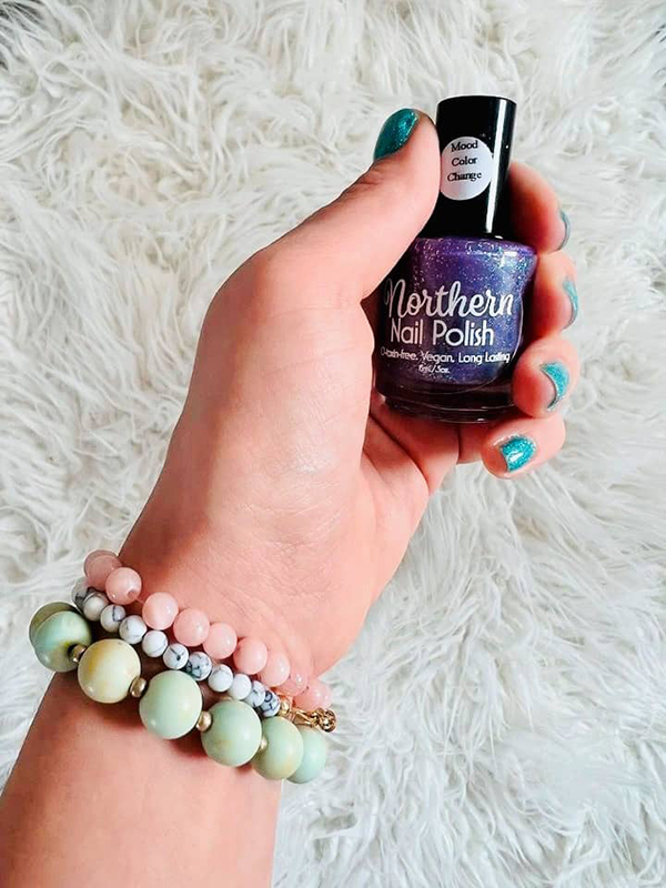 woman holding a bottle of vegan color changing nail polish