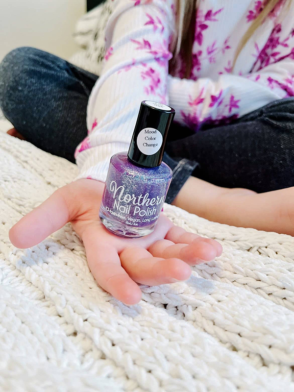 little girl holding purple color changing nail polish
