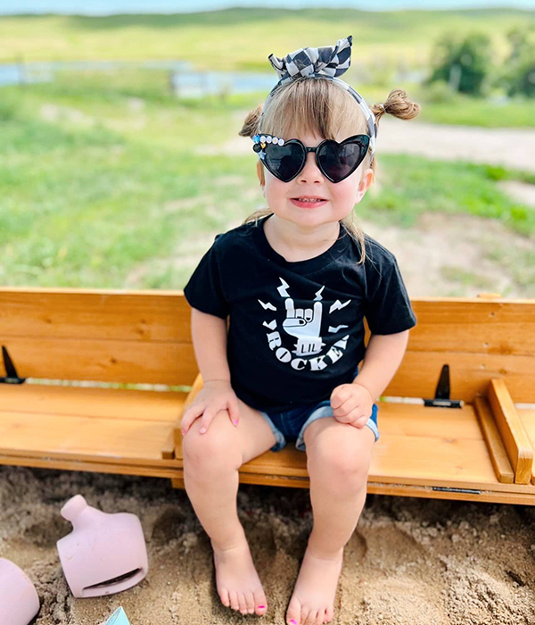 little girl wearing a lil rocker tee from the June 2023 Howdy Baby gift boxes for toddlers and kids