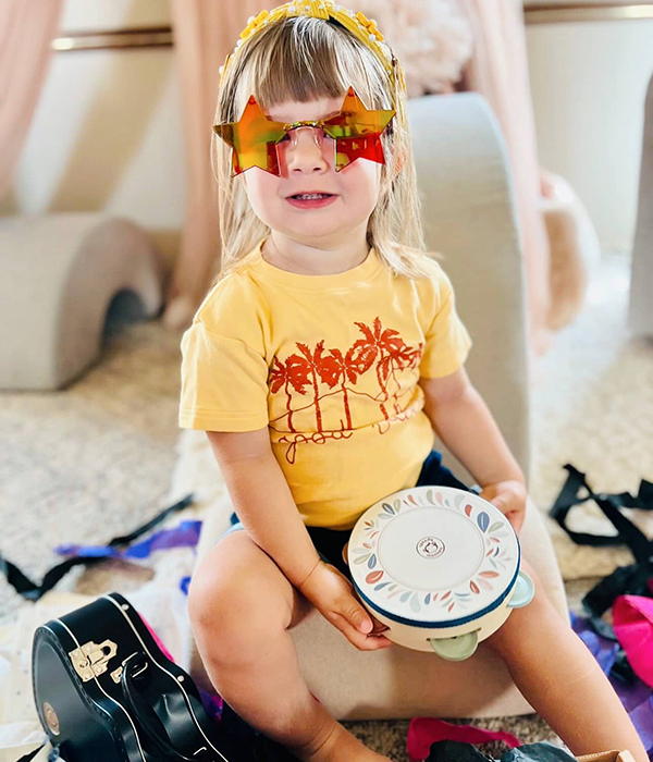 little girl holding a tambourine from Howdy Baby music themed gift boxes for toddlers