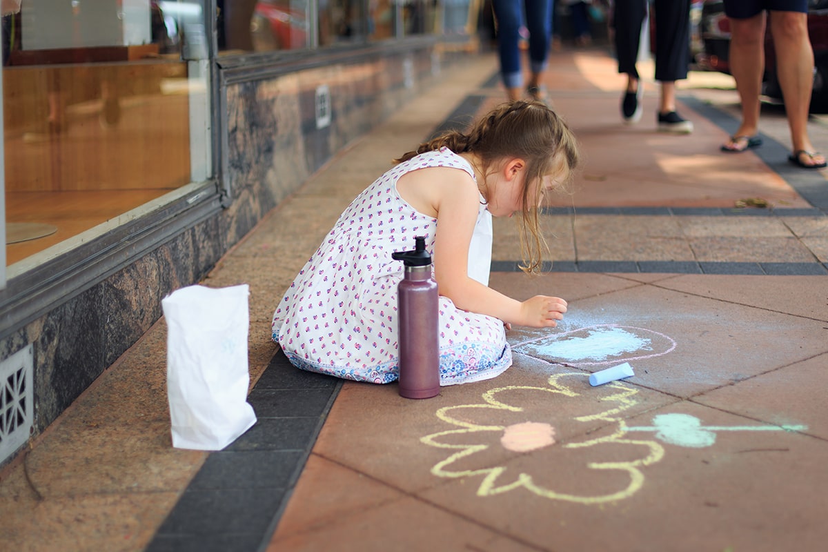 girl playing with sidewalk chalk