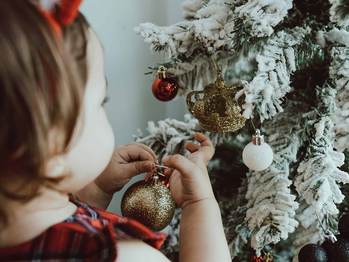 little girl decorating Christmas tree