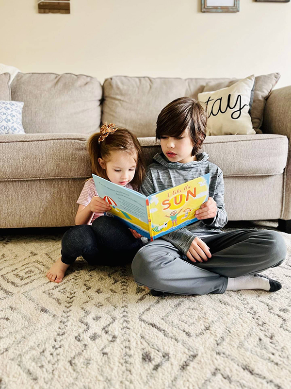 two kids reading a book from the April 2023 Howdy Baby kids box
