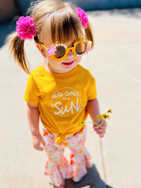 little girl wearing a sunny t-shirt from the April 2023 Howdy Kids box