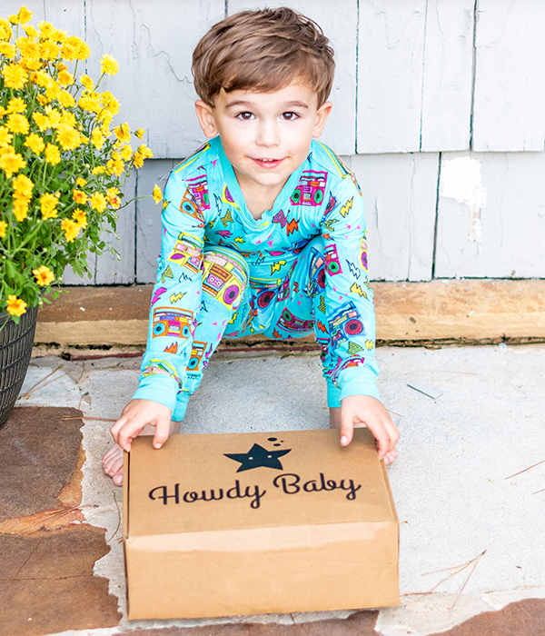 little boy holding the September 2023 Howdy Kids cooking themed subscription box