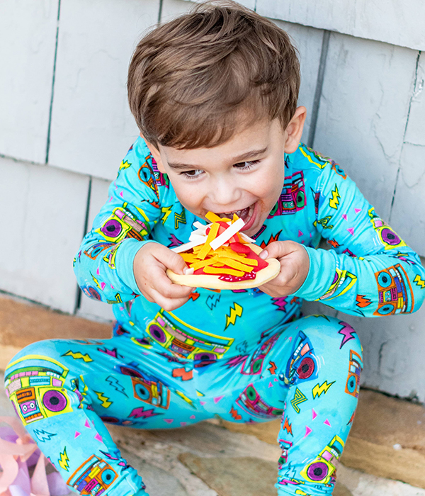 little boy pretending to eat a felt pizza from the September 2023 Howdy Kids cooking subscription box