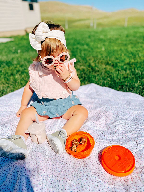 little girl with kids snack cup from children's subscription box