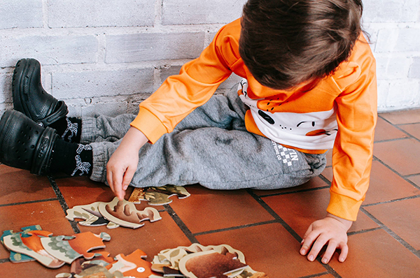 little boy putting together a puzzle from November 2023 Howdy Baby kids subscription boxes
