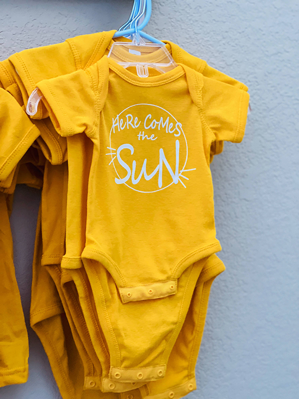 here comes the sun onesie from the April 2023 Howdy Baby maternity subscription box