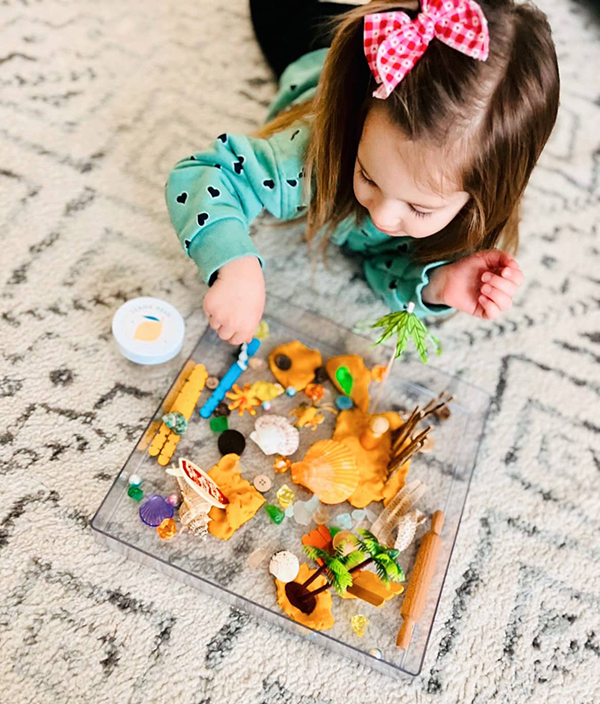 little girl playing with messy playdough