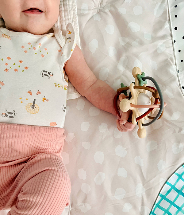 baby playing with a space themed satellite teether toy