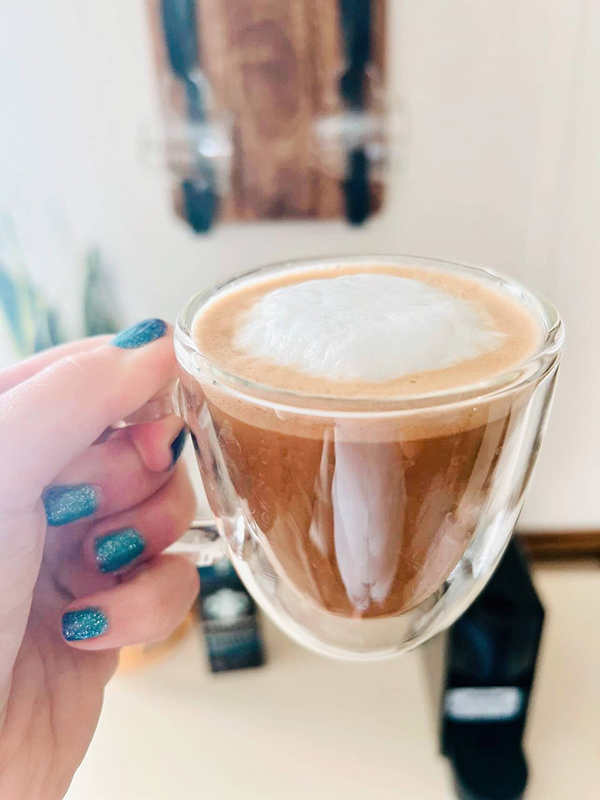 woman holding a cup of coffee showing off her mood changing nail polish