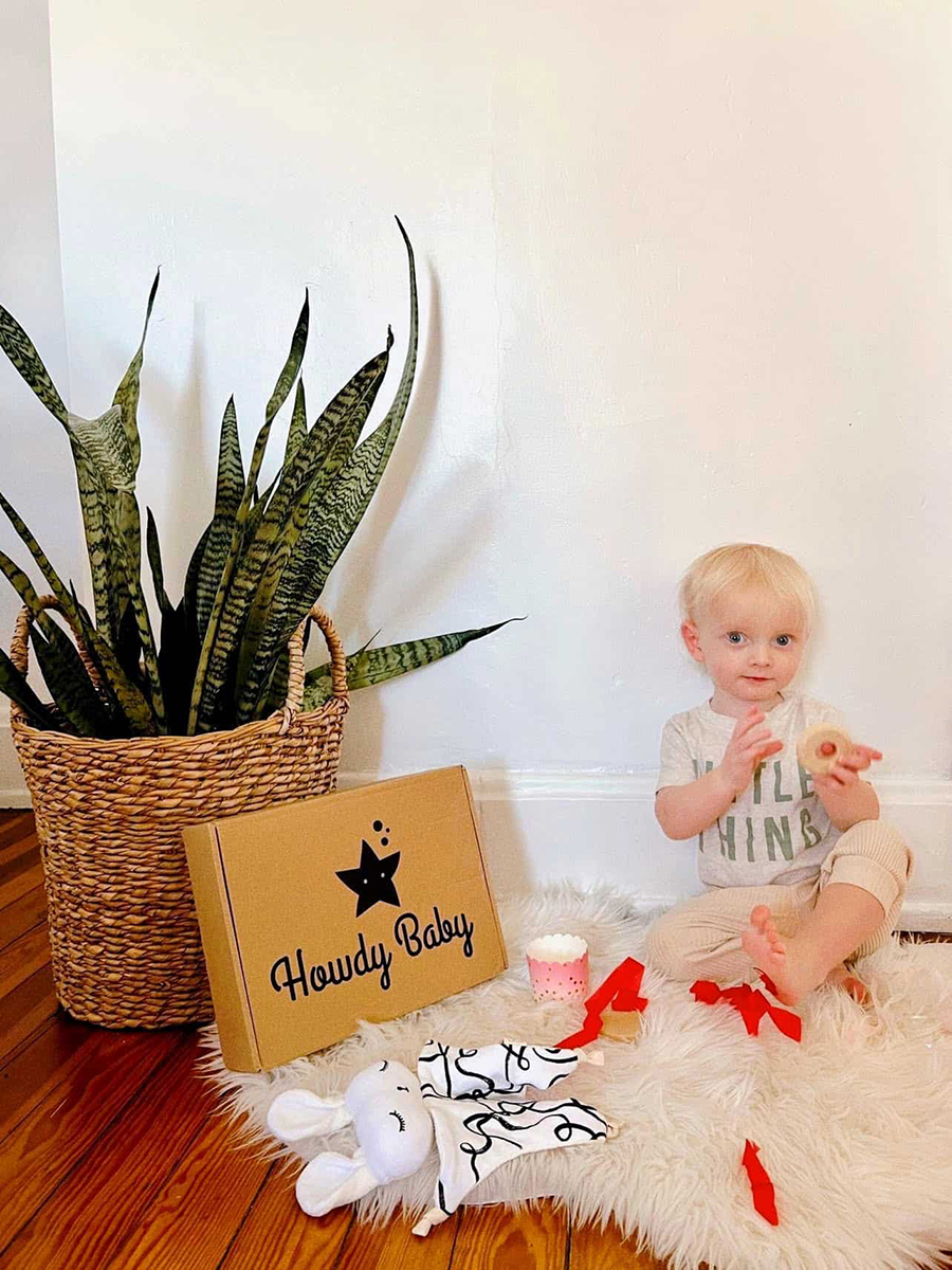 little boy opening his new baby gift box