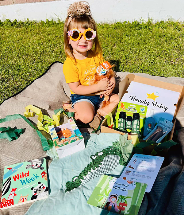 toddler girl unboxing her July 2023 Howdy Baby and newborn baby boxes