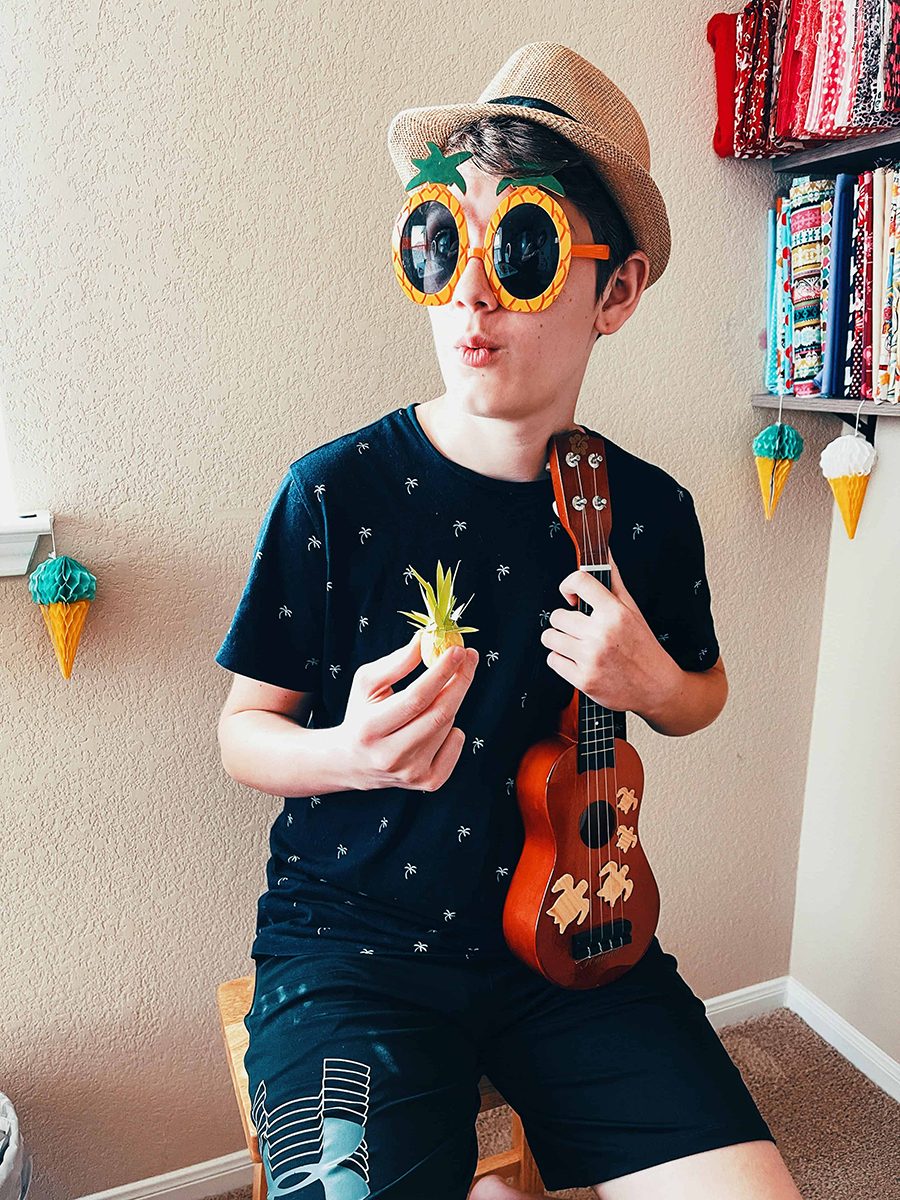 older kid holding a painted walnut pineapple