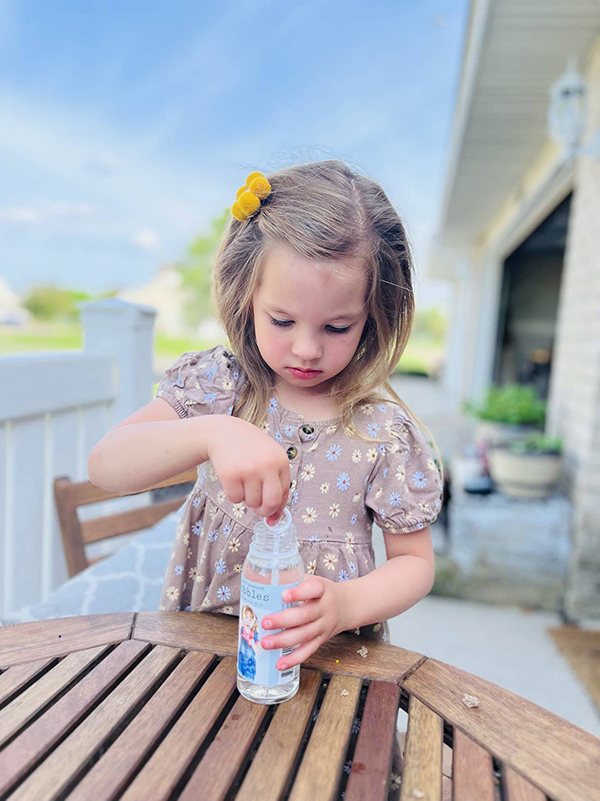 little girl playing with eco friendly plant bubbles