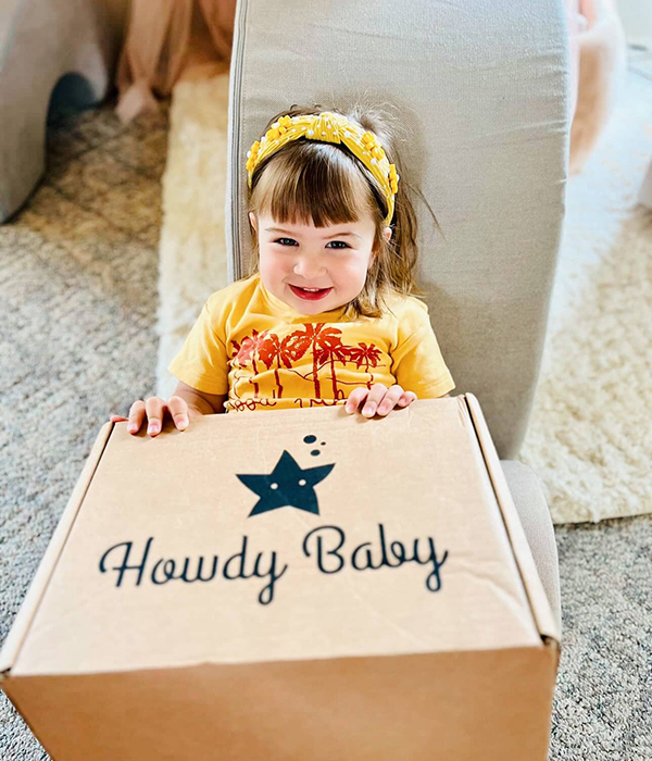 little girl holding the Howdy Baby mommy and me pregnancy subscription box