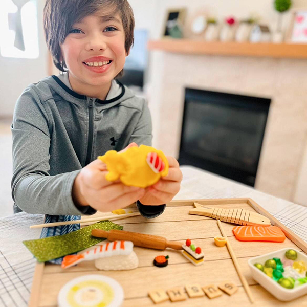 boy playing with a scented play dough sushi kit
