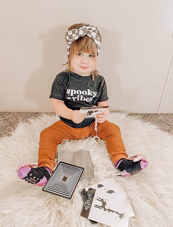 baby girl playing with sensory flashcards