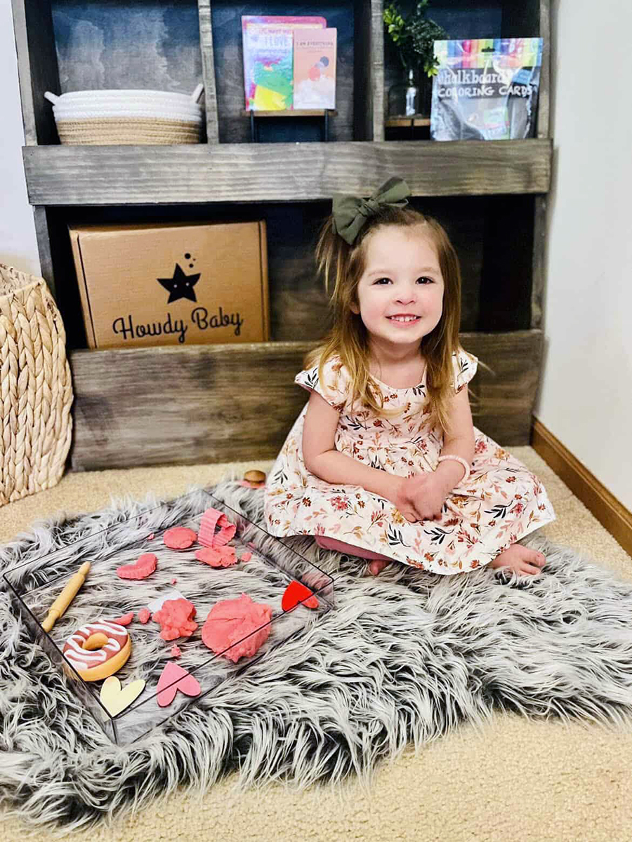 little girl playing with sensory kit from the Howdy Kids subscription box