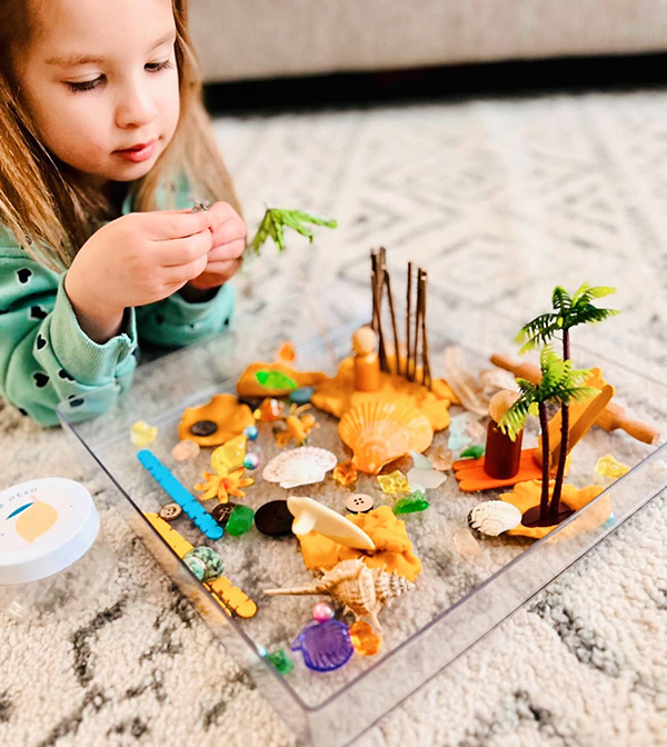 little girl using sensory manipulatives to learn while she plays