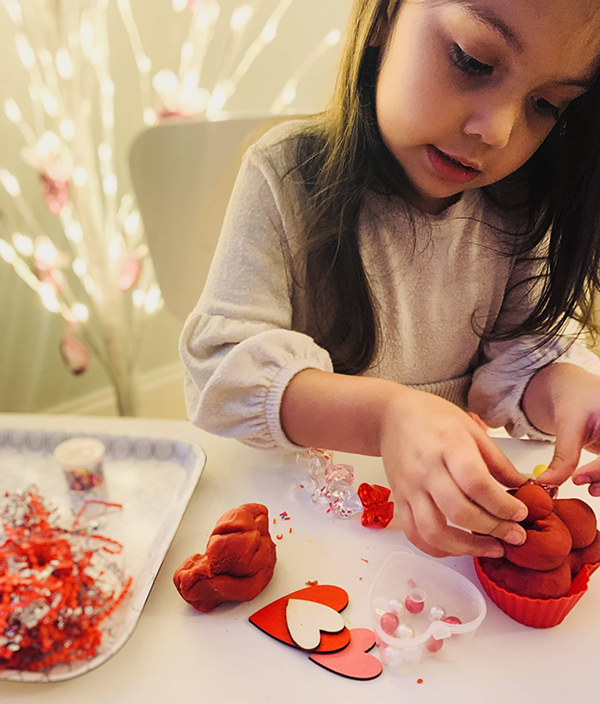 little girl playing with scented sensory play dough manipulatives