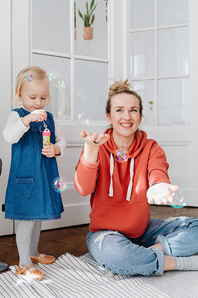 toddler girl and her mom playing with bubbles