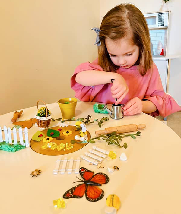 little girl playing with spring themed sensory kit