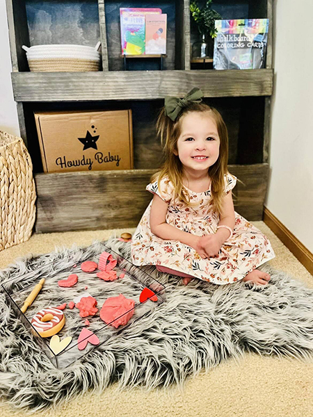 little girl playing with pink sensory playdough kits