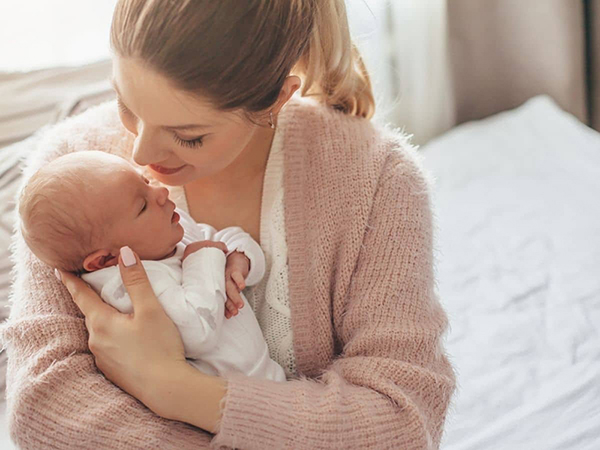 mom initiating skin to skin contact with her infant baby